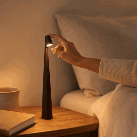 Hand schaltet kabellose LED Tischlampe NordLight per Touch ein und wählt die Helligkeit
