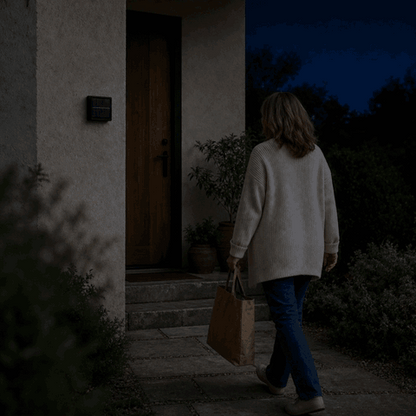 Solar Wandleuchte SolarGlow schaltet sich per Bewegungsmelder ein, als die Frau zur Haustür geht