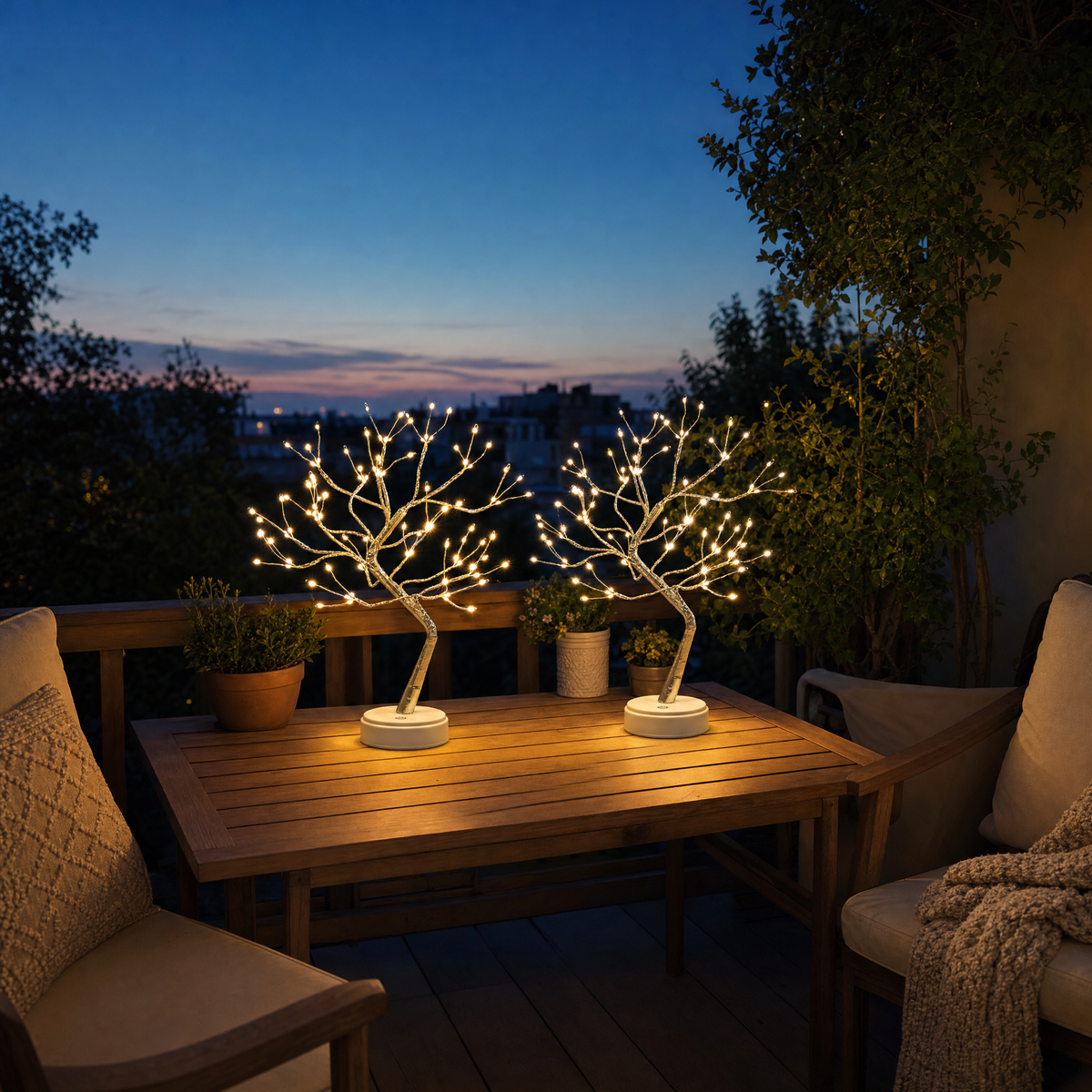 Zwei kabellose LED Lichterbaum Lampen auf dem Balkontisch am Abend